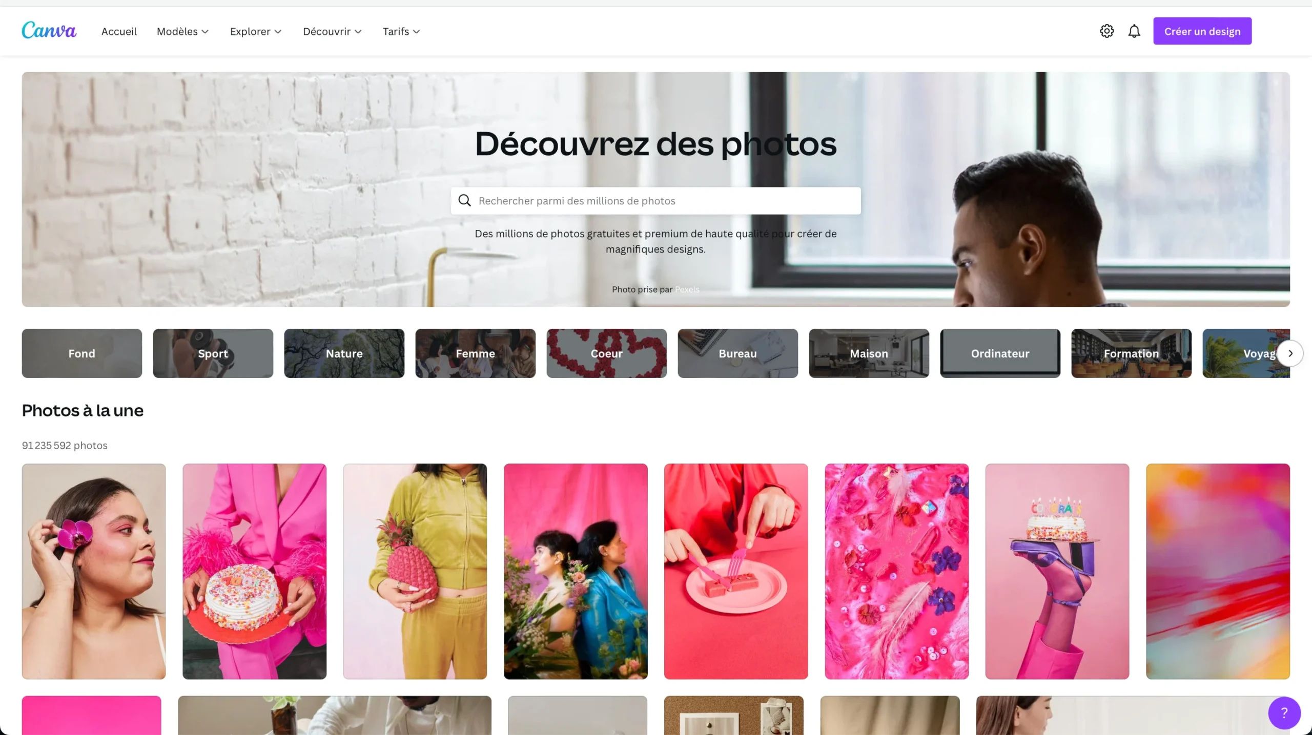 Capture d'écran de la page d'accueil de Canva montrant la section 'Découvrez des photos'. Des catégories de recherche sont affichées (Fond, Sport, Nature, Femme, Cœur, etc.). En dessous, une mosaïque de photos principalement aux couleurs vives et roses est visible, incluant des portraits et des natures mortes.